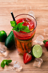 Fresh strawberry mojito drinks on a vintage wooden dark table. mocktail decorated with strawberries and mint