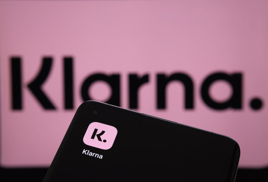 Klarna app seen on the&nbsp;screen of smartphone and Klarna logo on the screen behind. Concept for credit app. Stafford, United Kingdom, June 19 2022