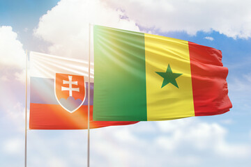 Sunny blue sky and flags of senegal and slovakia