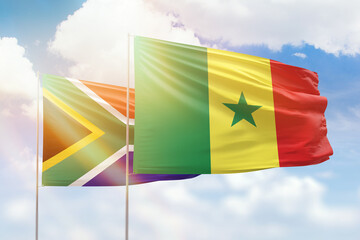 Sunny blue sky and flags of senegal and south africa