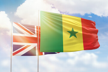 Sunny blue sky and flags of senegal and united kingdom