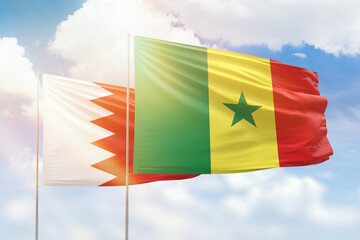 Sunny blue sky and flags of senegal and bahrain
