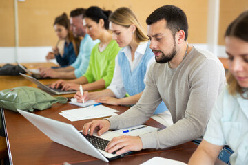 Obraz premium Adult students listening task for exam in the classroom