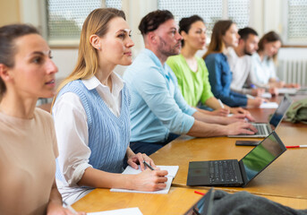 Small group of students attentively listening to lecture in university classroom