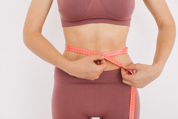 Happy woman measures the ruler her belly. The concept of diet and weight loss.
