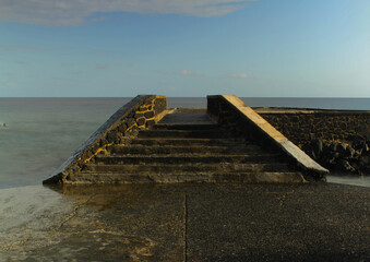 Foot bridge near seashore in moroni Island during rain and rainbow