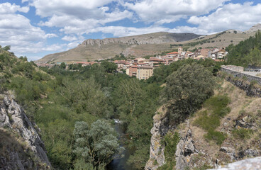 Fototapeta na wymiar Beautiful views of the village of Anguiano surrounded by mountains and lots of vegetation with a blue summer sky, Spain.