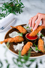 Japanese dish , battered deep fried seafood Tiger Prawns . Served with sauce