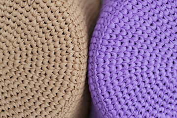 textured knitted background with two crochet hats of brown and lavender color
