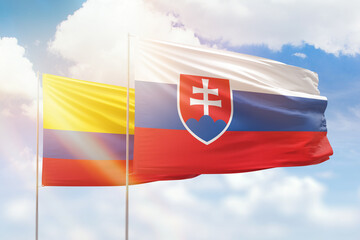 Sunny blue sky and flags of slovakia and colombia