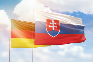 Sunny blue sky and flags of slovakia and germany