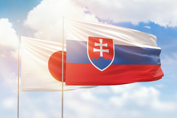 Sunny blue sky and flags of slovakia and japan