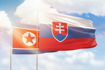 Sunny blue sky and flags of slovakia and north korea