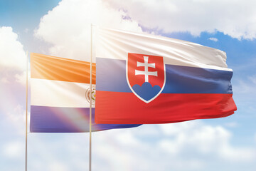 Sunny blue sky and flags of slovakia and paraguay