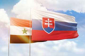 Sunny blue sky and flags of slovakia and syria