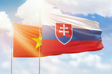 Sunny blue sky and flags of slovakia and vietnam