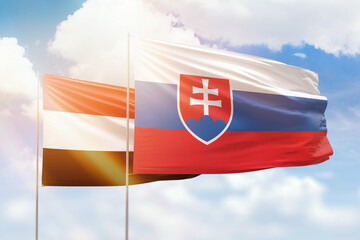Sunny blue sky and flags of slovakia and yemen
