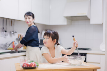 Obraz na płótnie Canvas 料理を手伝う女の子とお母さん