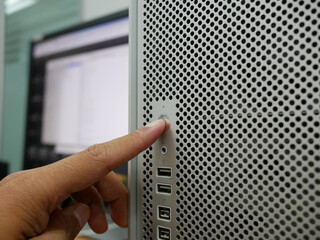 finger pushing on start button office computer PC.

