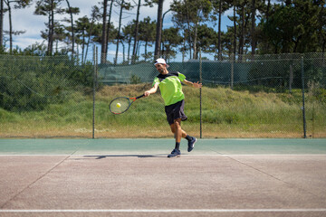 Tennis player hitting forehand at ball
