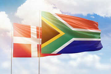Sunny blue sky and flags of south africa and denmark