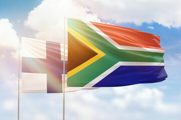 Sunny blue sky and flags of south africa and finland