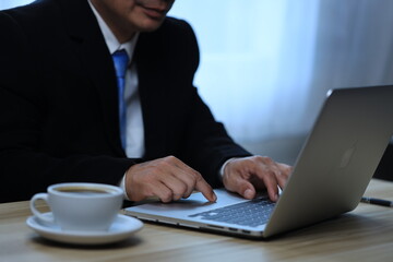 Hand of businessman  working with laptop smartphone while working on his project