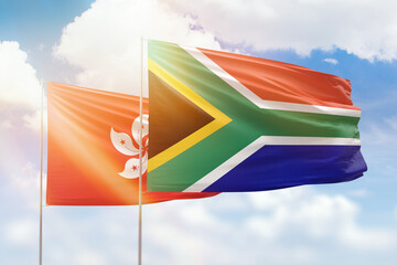 Sunny blue sky and flags of south africa and hong kong