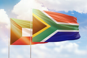 Sunny blue sky and flags of south africa and kuwait