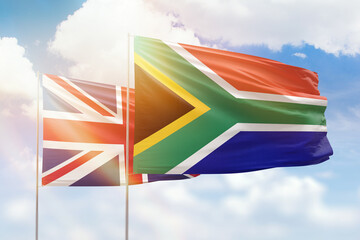 Sunny blue sky and flags of south africa and united kingdom