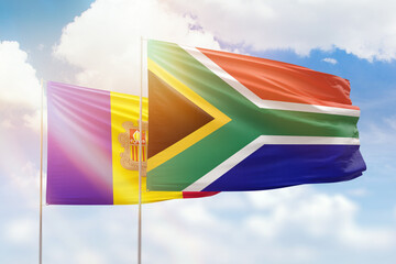 Sunny blue sky and flags of south africa and andorra