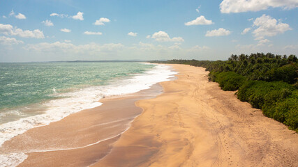 Fototapeta na wymiar Seascape with tropical sandy beach and blue ocean. Sri Lanka.