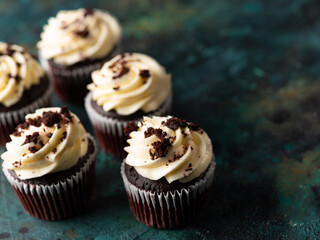 Festive dessert - delicious chocolate muffins garnished with whipped cream and grated dark chocolate. Low angle view. Restaurant, confectionery, cafe, hotel, banquet.