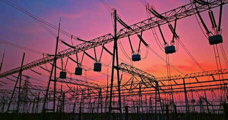 Aerial footage of high voltage power tower in substation. Transmission power line. Electricity pylons and sky clouds background at sunset.