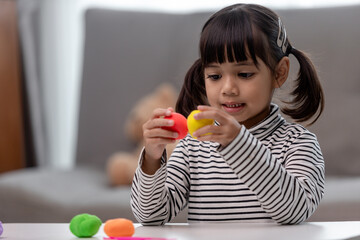 Asian kids play with clay molding shapes, learning through play