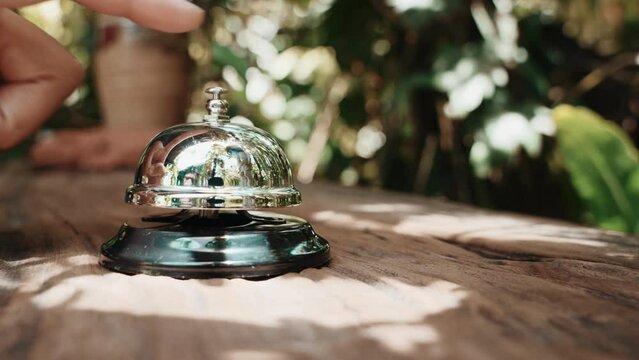 Hospitality hotel. Customer hand ringing service bell at coffee cafe shop for calling the staff to receive the menu, Woman finger touching to ring bell