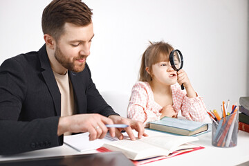 Girl with Down syndrome studying with her teacher at home