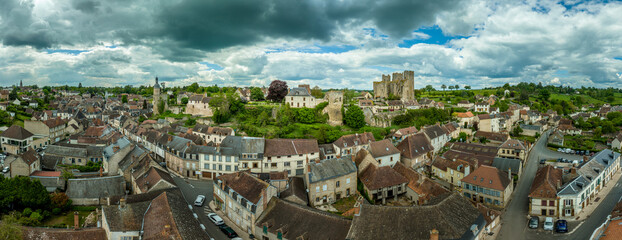 Aerial view of Bourbon-L'Archambault ancient castle of the royal family ruined during the revolution, with three circular Gothic towers surviving on a hilltop over the sleepy small French town 