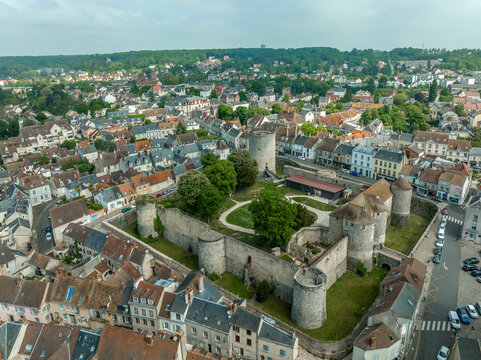 Aerial view of Dourdan castle built on a square pattern, with towers at three of the corners and an isolated donjon at the fourth. The walls are punctuated by towers in the middle of each side