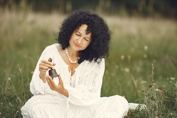 Adult woman showing meditation tool on meadow