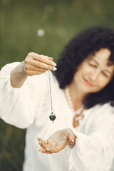 Adult woman showing meditation tool on meadow