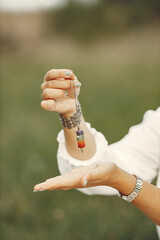 Adult woman showing meditation tool on meadow