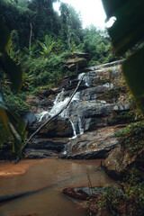 Naklejka na ściany i meble Waterfall in the tropical forest in the rainy season