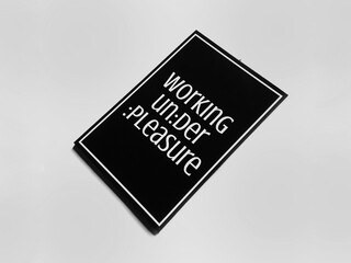 Inspirational Quotes Poster "Working Under Pleasure" Lying on the Greyscale Background