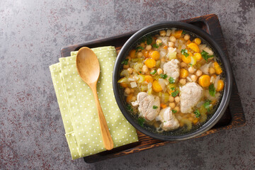 Italian pork and chickpea soup with vegetables close up in a bowl on the table. horizontal top view from above