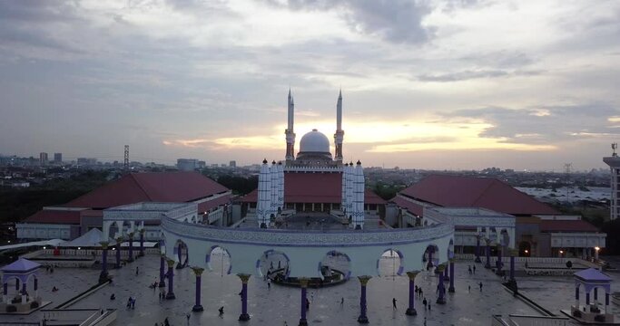 Reversal drone shot of the great Mosque of Central Java (MAJT) in suset time. Th sun is orange and the weather is cloudy.