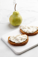 Bruschetta with cottage cheese ricotta cheese on marble white board and background. Appetizer for wine
