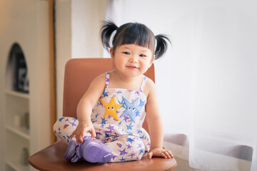 Happy cute baby smile and laugh in living room. 1 year 6 month baby in a living room use as concept of play, health, mood and motion of baby and kid development.