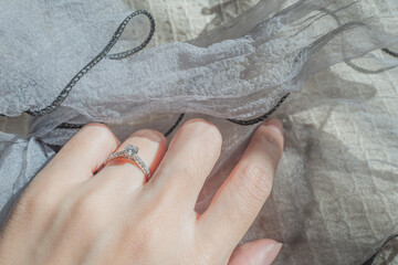 Close up of diamond ring on woman finger with sunlight and shadow background. Love, valentine,...