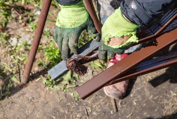 A worker paints metal at a construction site.